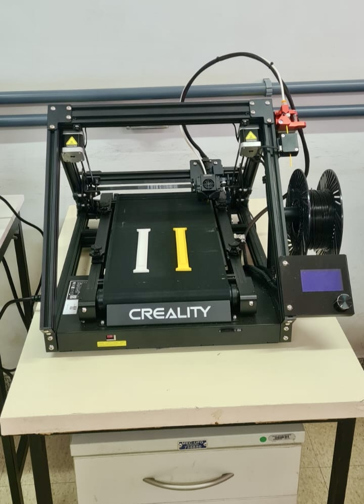 A foto mostra uma impressora 3D FDM Creality CR30, a qual tem o eixo Z infinito, ou seja, sua mesa de impressão é uma esteira.