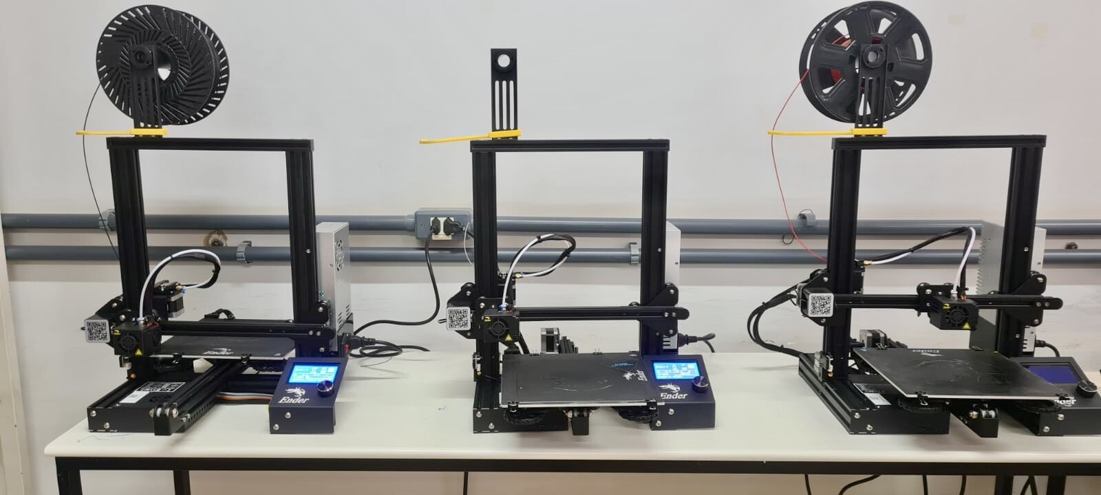 Foto com três impressoras 3D FDM, da linha Ender 3, da Creality.
