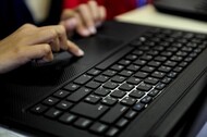 Imagem mostra mãos humanas digitando texto em teclado de computador