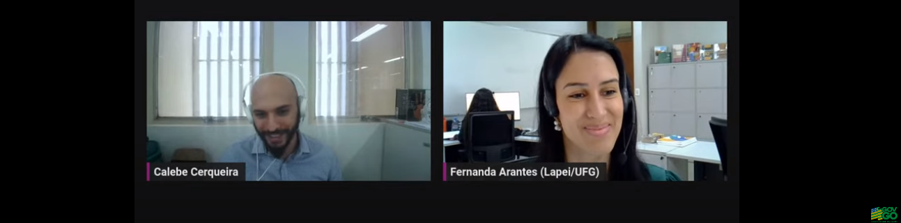 Print live 1 CGE - Na foto aparecem duas pessoas participando de live no YouTube. À esquerda, Calebe Cerqueira, homem, jovem, branco, careca, com barba preta, vestido de camisa azul, com fones de ouvido brancos (headset) e ao fundo uma parede branca com janelas. À direta, Fernanda Arantes, mulher, jovem, parda, cabelos pretos, blusa verde, fone de ouvido preto (headset) e ao fundo um ambiente de trabalho com outras mesas, pessoas e armários. 