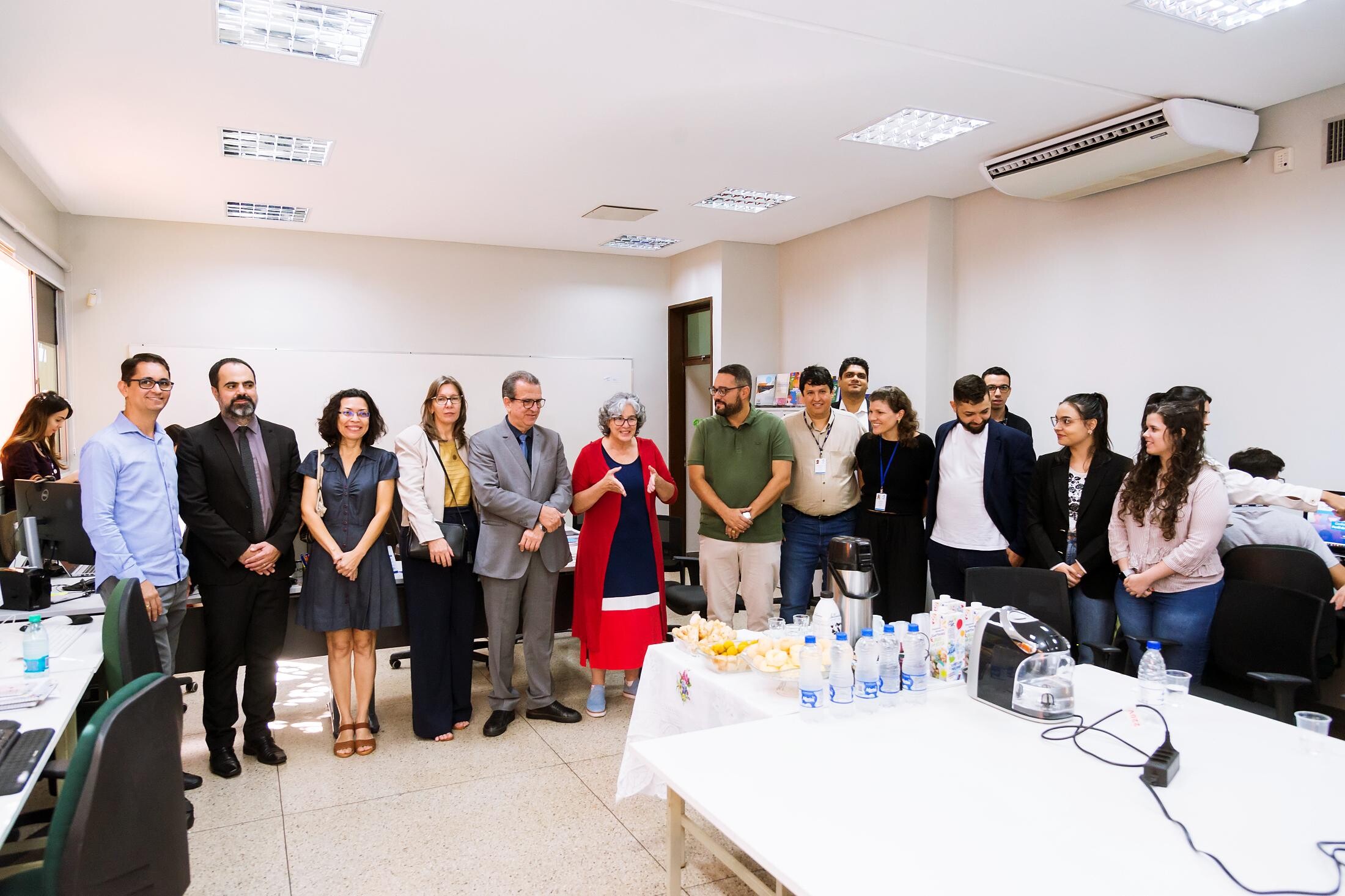 Nesta imagem aparece várias pessoas em uma sala branca do Media Lab. 