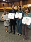 Foto com 4 Docentes homenageados segurando um diploma. 