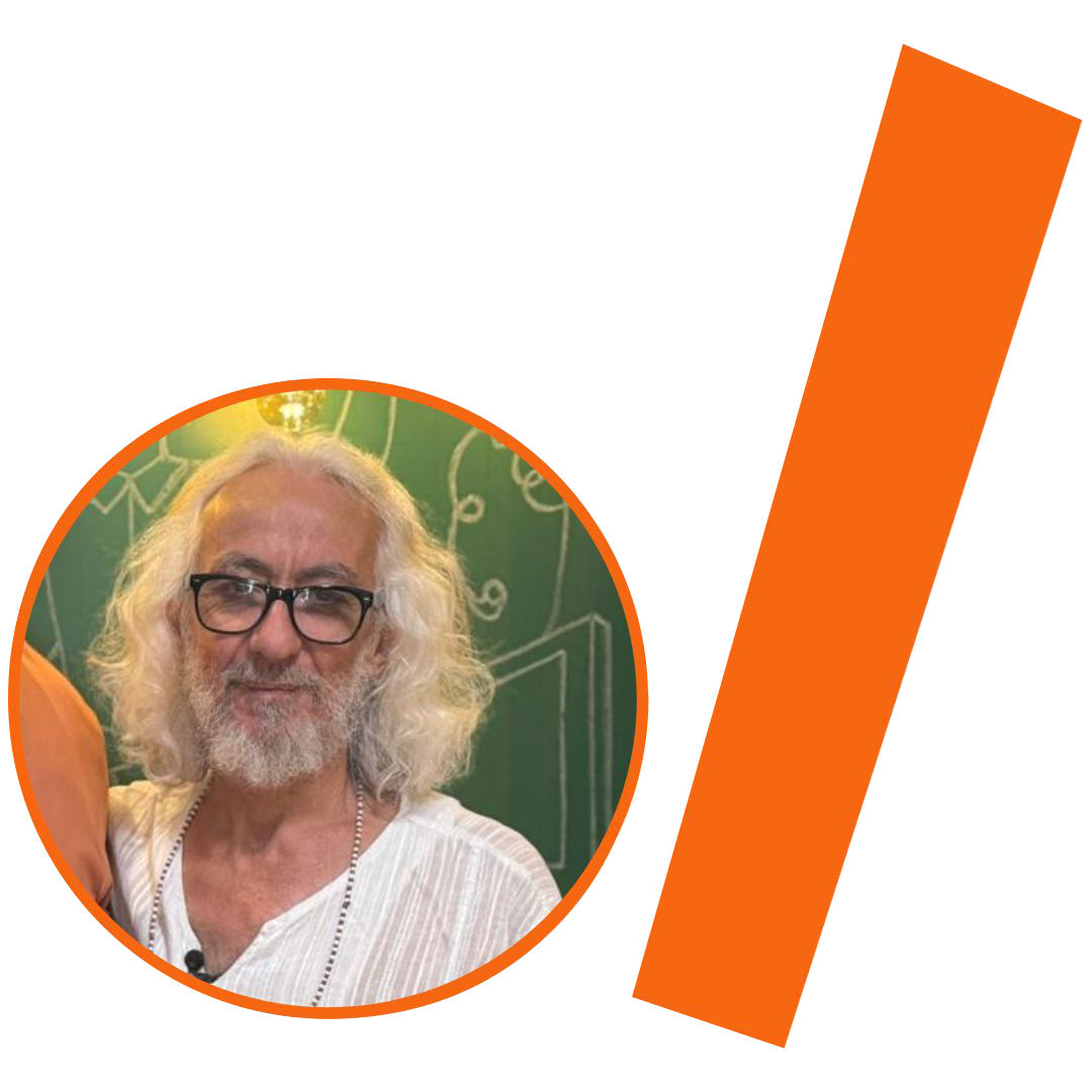 #ParaTodosVerem: Fotografia colorida em plano médio de um homem de meia-idade com cabelos longos, volumosos e brancos, e barba também branca e cheia. Ele usa óculos de grau com armação preta e olha para a câmera com um leve sorriso. Veste uma camisa branca de tecido texturizado com discretas listras verticais e um colar de contas brancas. A imagem está inserida em um recorte circular com borda laranja. Ao fundo, uma parede verde com desenhos em giz branco e a luz de uma lâmpada de filamento. À direita do círculo, há uma barra grossa e inclinada também na cor laranja. O conjunto visual, sobre fundo branco, segue a identidade visual do projeto.