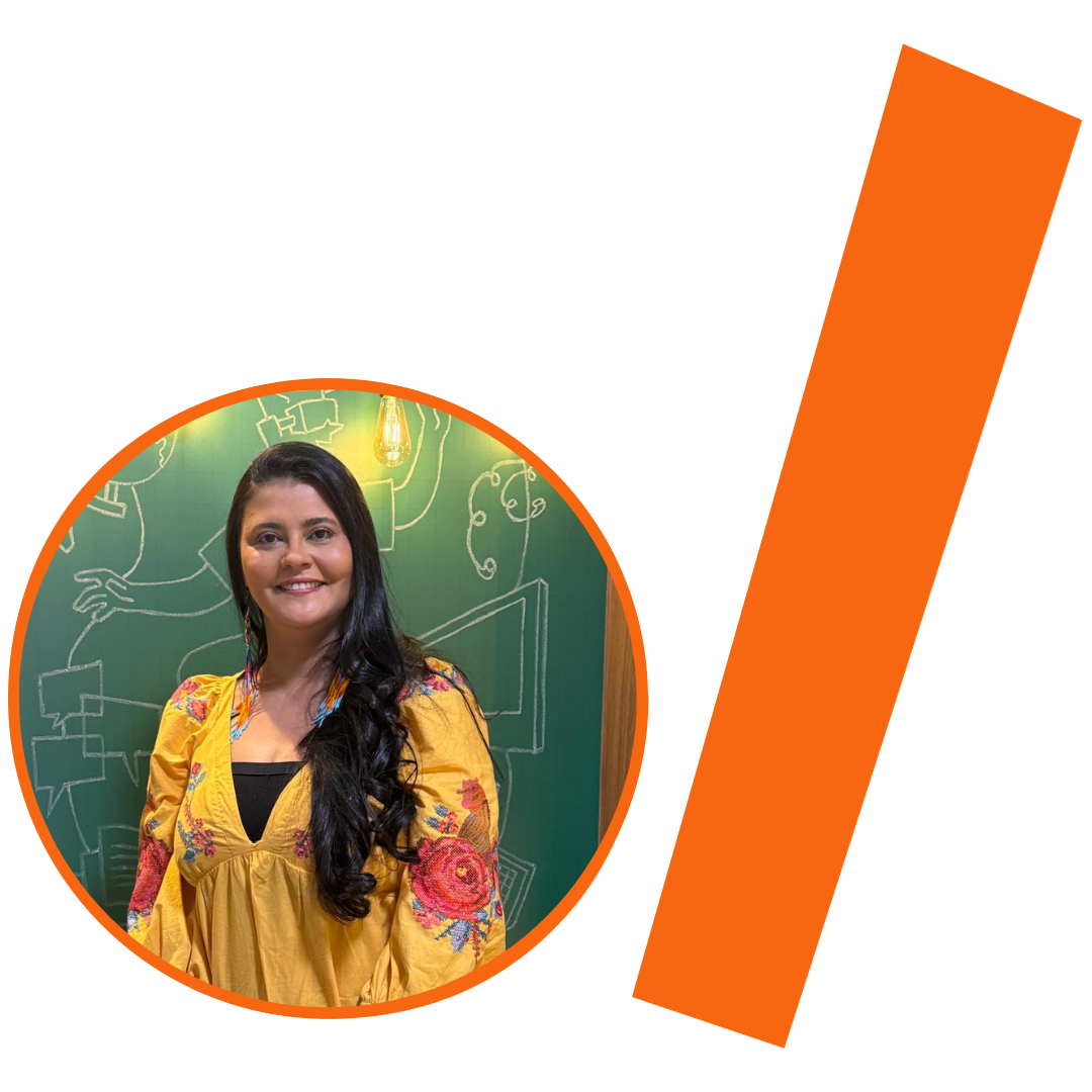 #ParaTodosVerem: Fotografia colorida em plano médio de uma mulher parda de pele clara, com longos cabelos pretos ondulados, que caem sobre o ombro esquerdo. Ela sorri para a câmera e usa brincos de franjas coloridas. Veste uma bata amarela com decote em "V" e bordados florais coloridos nas mangas e no busto, sobre uma blusa preta. A imagem está inserida em um recorte circular com borda laranja. Ao fundo, uma parede verde com desenhos em giz branco e a luz de uma lâmpada de filamento acesa. À direita do círculo, há uma barra grossa e inclinada também na cor laranja. O conjunto visual mantém a identidade visual padrão do projeto.