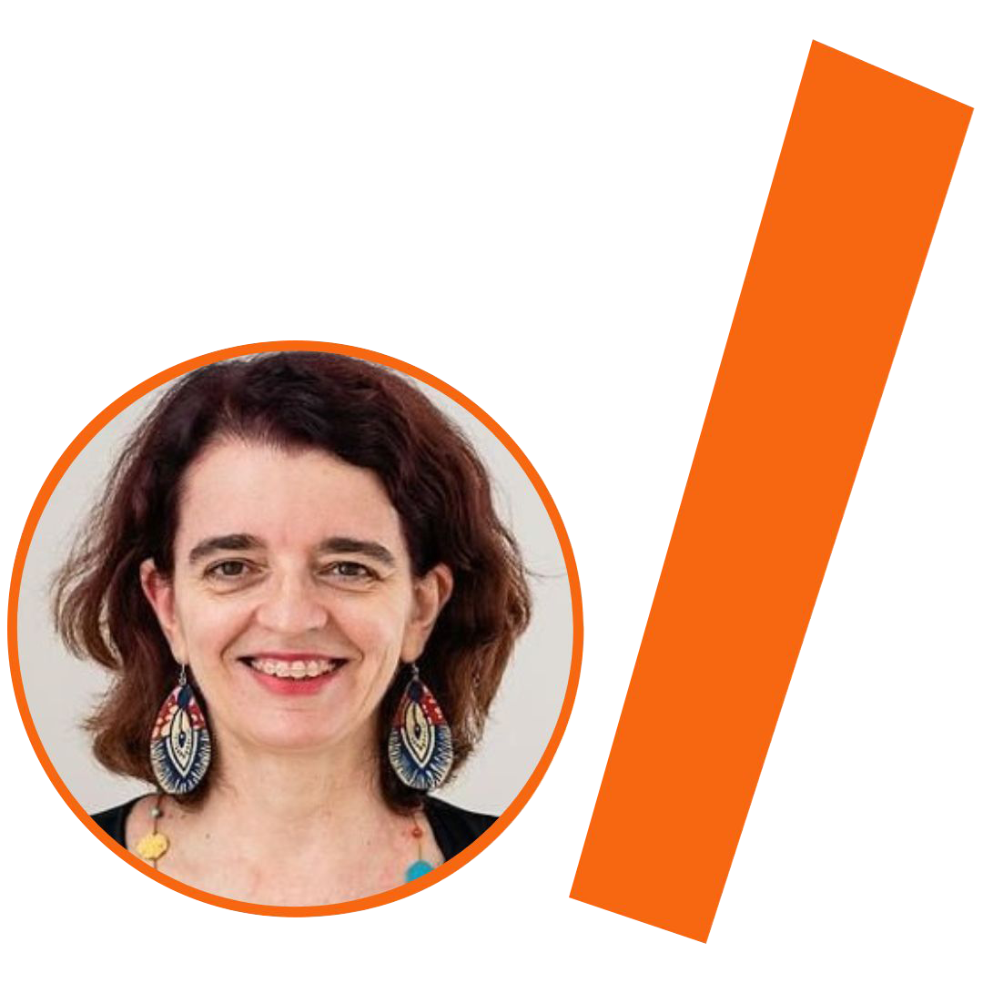 #ParaTodosVerem: Fotografia colorida de uma mulher branca com cabelos castanhos ondulados na altura dos ombros. Ela sorri para a câmera e usa brincos grandes em formato de gota com estampas coloridas em tons de azul, vermelho e bege. É possível ver parte de um colar com contas coloridas. A imagem está inserida em um recorte circular com borda laranja. À direita do círculo, há uma barra grossa e inclinada também na cor laranja. O conjunto visual está mantendo o padrão da identidade visual do projeto.