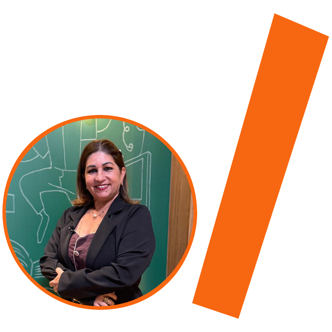 #ParaTodosVerem: Fotografia colorida em plano médio de uma mulher branca, com cabelos castanhos claros na altura dos ombros. Ela sorri para a câmera, de pé, com os braços cruzados na frente do corpo. Veste um paletó preto sobre uma blusa roxa escura, com um colar fino e pingente visível. A imagem está inserida em um recorte circular com borda laranja. Ao fundo da foto, vê-se um quadro-negro verde com desenhos abstratos e lineares em giz branco, além de parte de uma estrutura de madeira desfocada. À direita do círculo, há uma barra grossa e inclinada também na cor laranja. O conjunto visual está mantendo a identidade visual padrão do projeto.