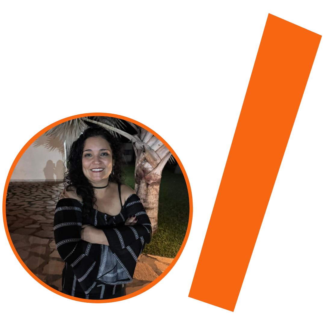 #ParaTodosVerem: Fotografia colorida de uma mulher parda, de pé, sorrindo para a câmera com os braços cruzados na frente do corpo. Ela tem longos cabelos pretos e cacheados e veste uma blusa preta de mangas longas com estampas de listras horizontais e detalhes brancos nos punhos, deixando os ombros à mostra. Ela usa uma gargantilha preta fina. A imagem está inserida em um recorte circular com borda laranja. Ao fundo da foto, vê-se um ambiente externo à noite, com piso de pedras rústicas e o tronco de um coqueiro à direita. À direita do círculo, há uma barra grossa e inclinada também na cor laranja. O conjunto visual segue a identidade visual padrão do projeto.