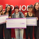#ParaTodosVerem Foto em grupo de todas as cinco vencedoras posando juntas na frente da parede vermelha com o letreiro do Salão Nobre. Elas seguram seus respectivos cheques simbólicos. As duas de vestido preto seguram o cheque do 3º lugar (esquerda); a jovem de cabelo ruivo o do 1º lugar (centro); e as duas de jaqueta e blusa marrom o do 2º lugar (direita). Todas sorriem para a câmera.