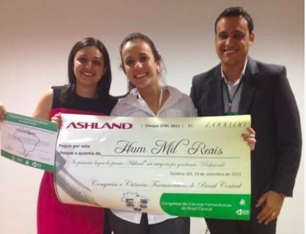 Imagem de três pessoas segurando uma premiação