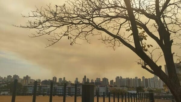 Cidade de Goiânia em campo aberto coberta por uma fumaça escura na parte da tarde