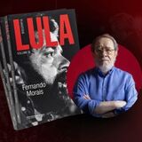 Arte de divulgação com fundo em tons de vermelho escuro. À esquerda, aparecem várias cópias empilhadas do livro Lula – Volume 2, de Fernando Morais. A capa destaca uma fotografia em preto e branco do rosto do presidente Luiz Inácio Lula da Silva em perfil, com o título “LULA” em letras grandes vermelhas.

À direita, há a imagem do escritor Fernando Morais, um homem idoso de cabelos grisalhos, barba curta e óculos. Ele veste uma camisa azul de mangas compridas e está com os braços cruzados, olhando para a câmera. Atrás dele, um círculo vermelho destaca sua figura.

O conjunto da imagem tem um visual sóbrio e institucional, remetendo ao lançamento da nova biografia de Lula escrita por Fernando Morais.