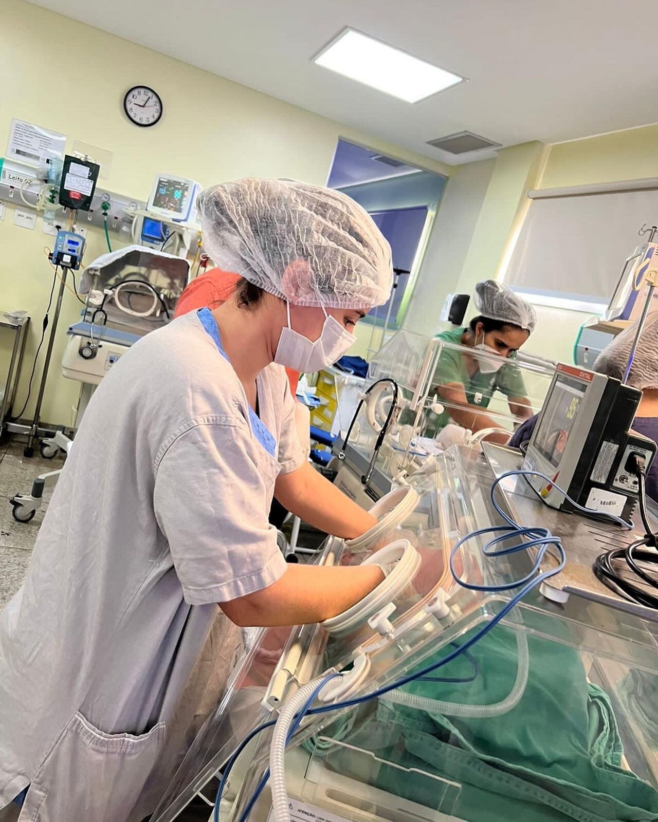 Residente atendendo bebê em incubadora na UTI Neonatal