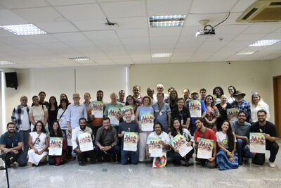 Fotos_Ensaio_Geral_Acof2026_04: foto final com todos os participantes do ensaio geral, segurando cartazes da Acof 2026