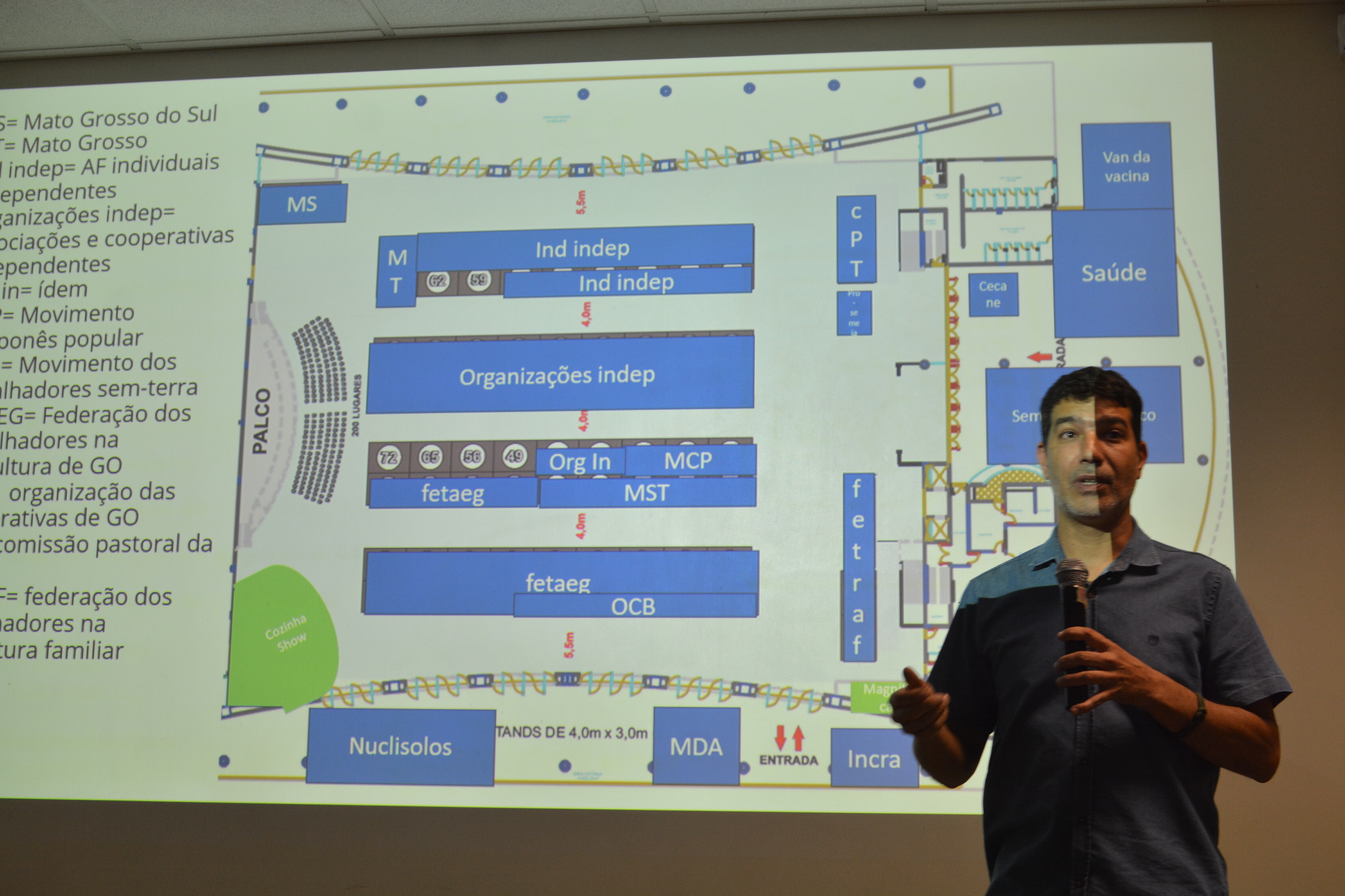 Professor Thiago Verano com o mapa da feira ao fundo