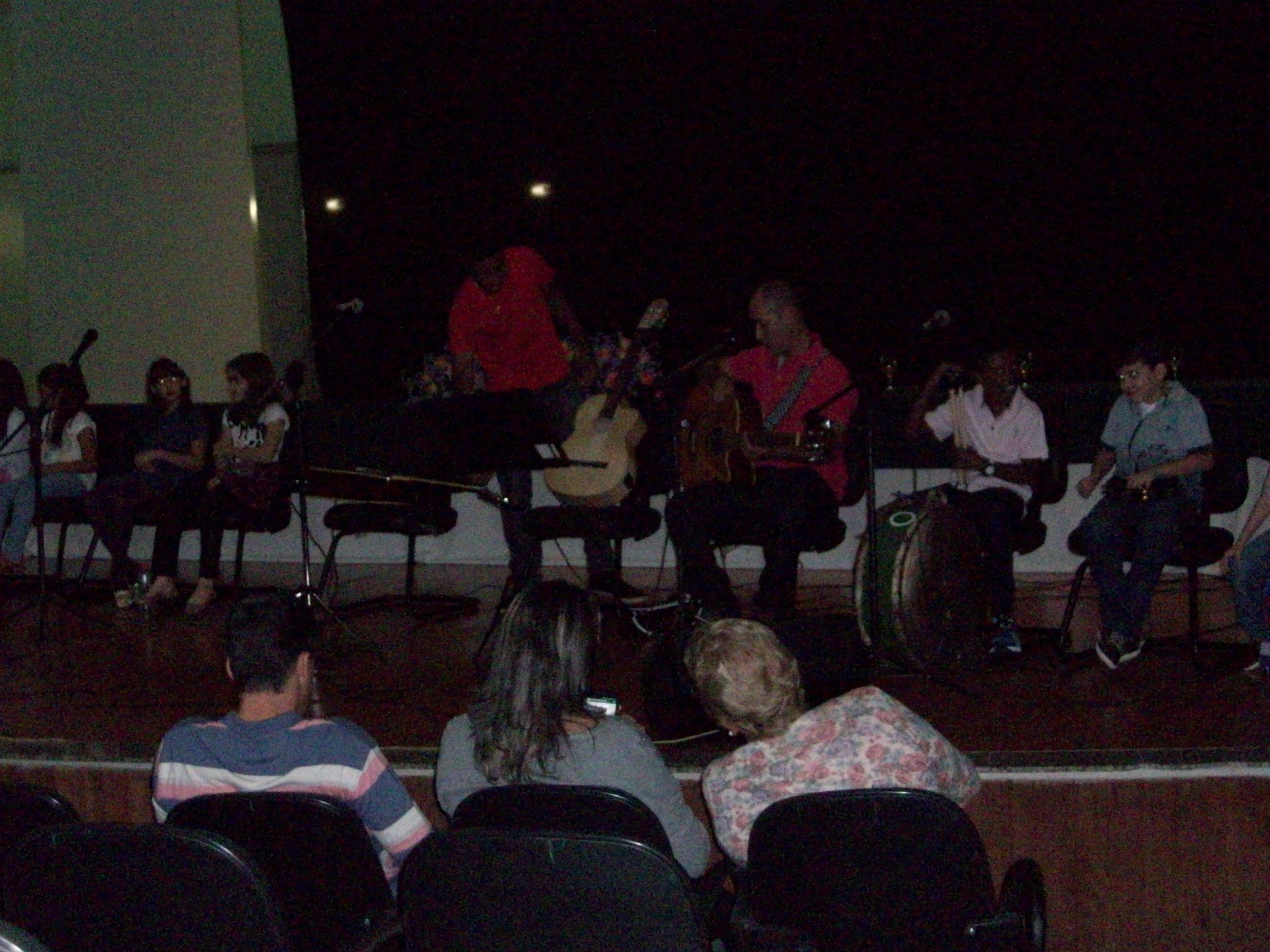 Tio Henrique e banda no palco  com as crianças se apresentando 