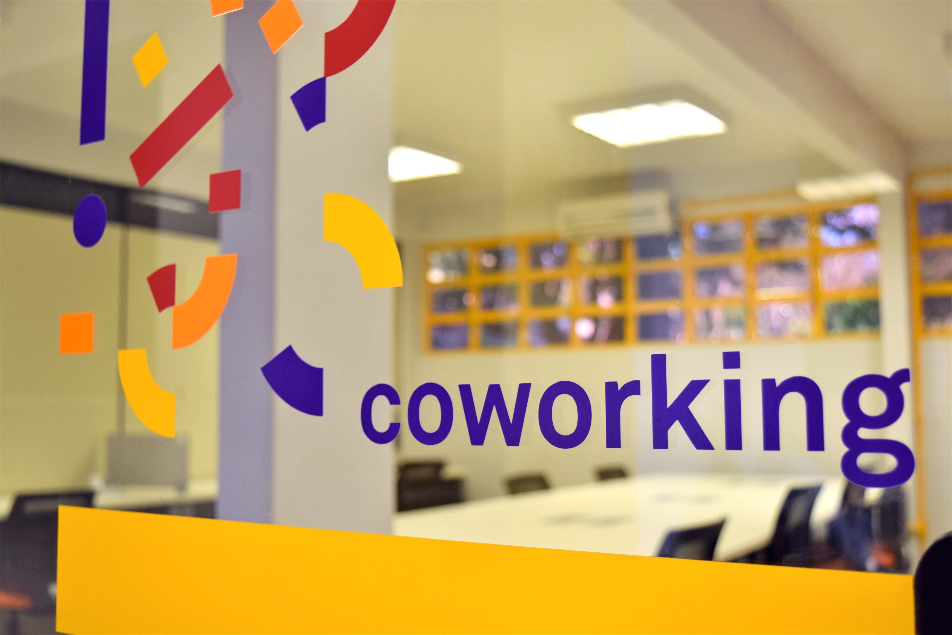 Ambiente de coworking do CEI/UFG, com a identidade visual aplicada no vidro
