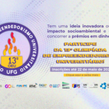 O banner horizontal da 13ª Olimpíada de Empreendedorismo Universitário da UFG apresenta um fundo em tons pastéis de roxo e rosa com grafismos circulares. No centro, o logotipo do evento destaca uma chama colorida, ladeado por dois jovens negros sorridentes que saltam comemorando entre emojis e ícones criativos. O texto principal convida pessoas com ideias inovadoras a buscarem prêmios em dinheiro, informando que as inscrições estão abertas até 22 de maio de 2026.