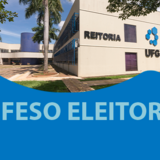 Ao fundo há a foto do prédio da reitoria, com uma parte azul com o escrito DEFESO ELEITORAL